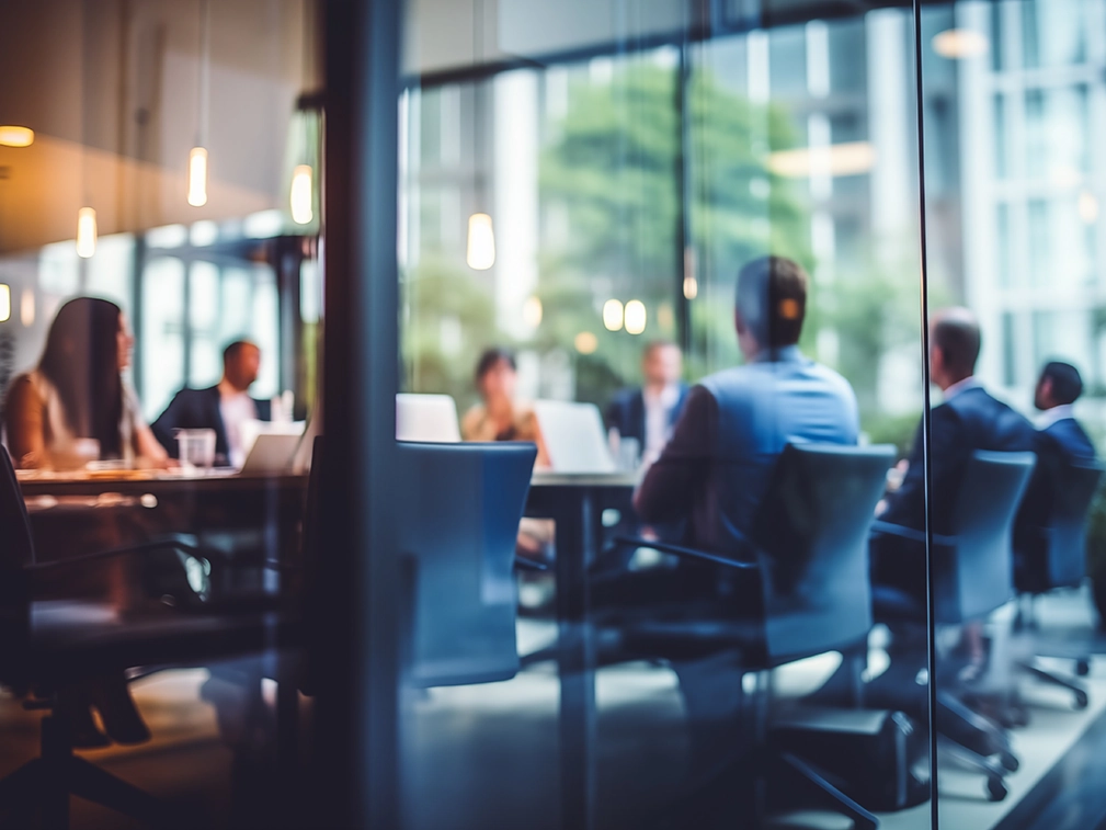 A board meeting behind glass.