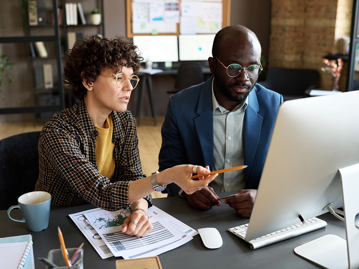 Two people discussing reports in an office.