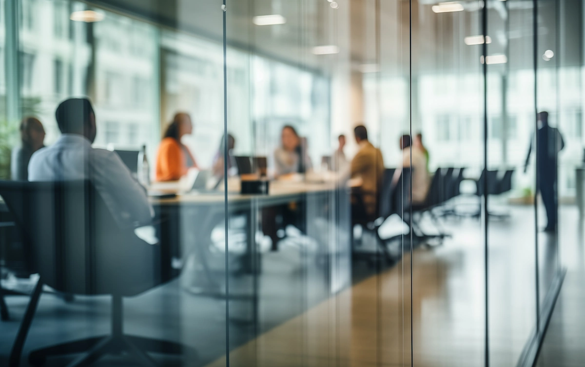 A meeting in a glass boardroom